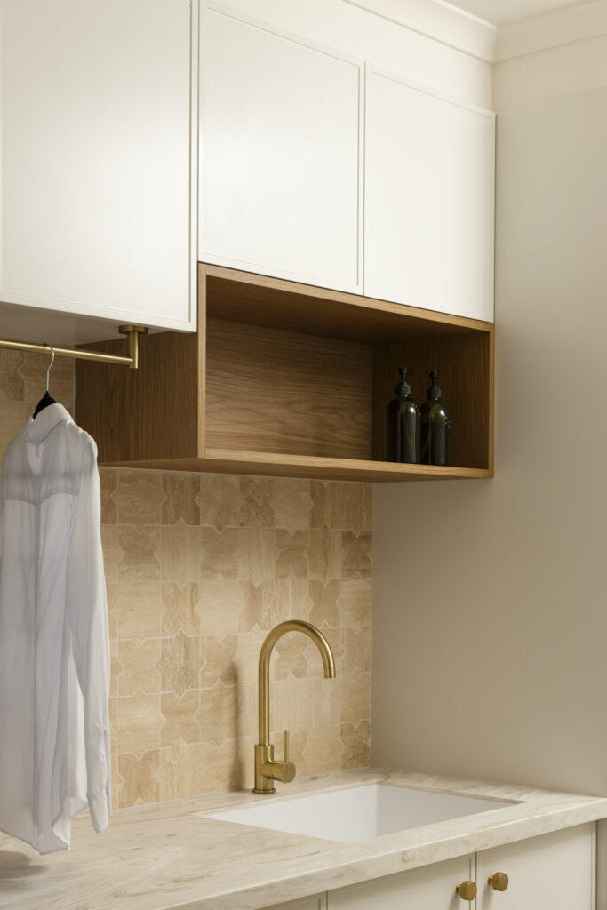 Modern laundry with brass tap and wooden shelving