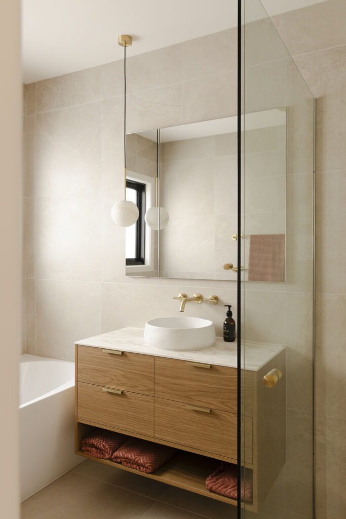 Modern bathroom vanity with timber cabinet and brass tapware